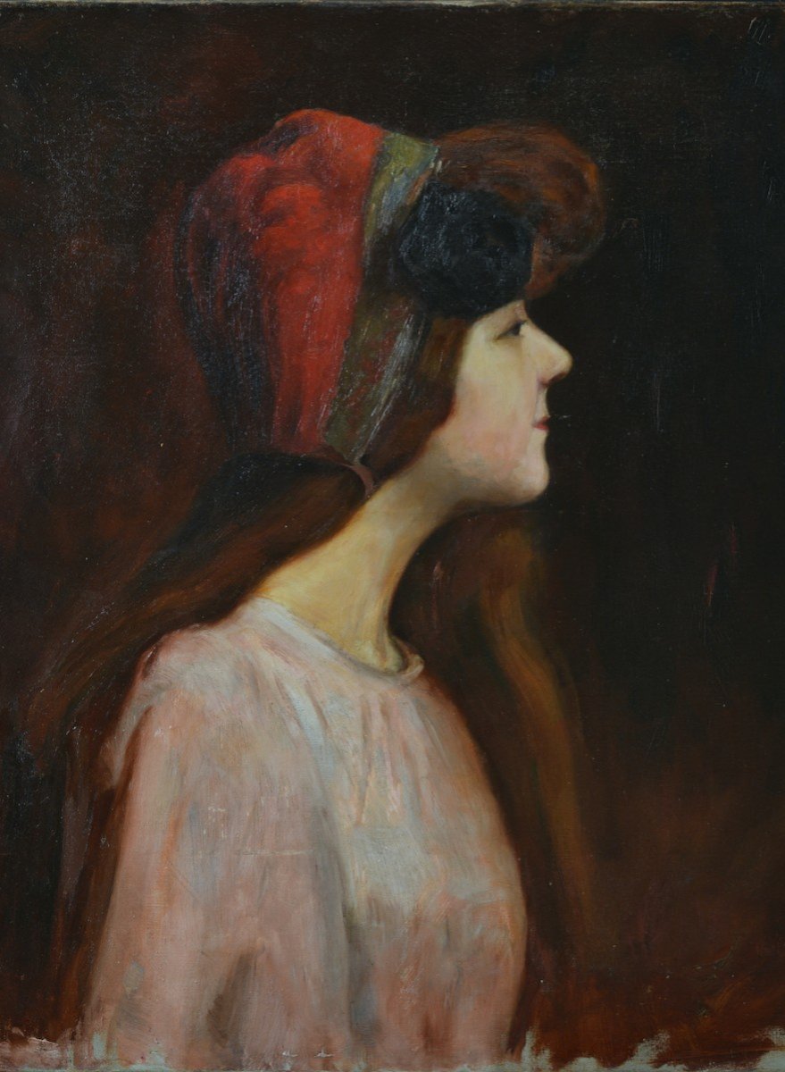 Portrait d'une jeune fille rousse de profil à la coiffe rouge